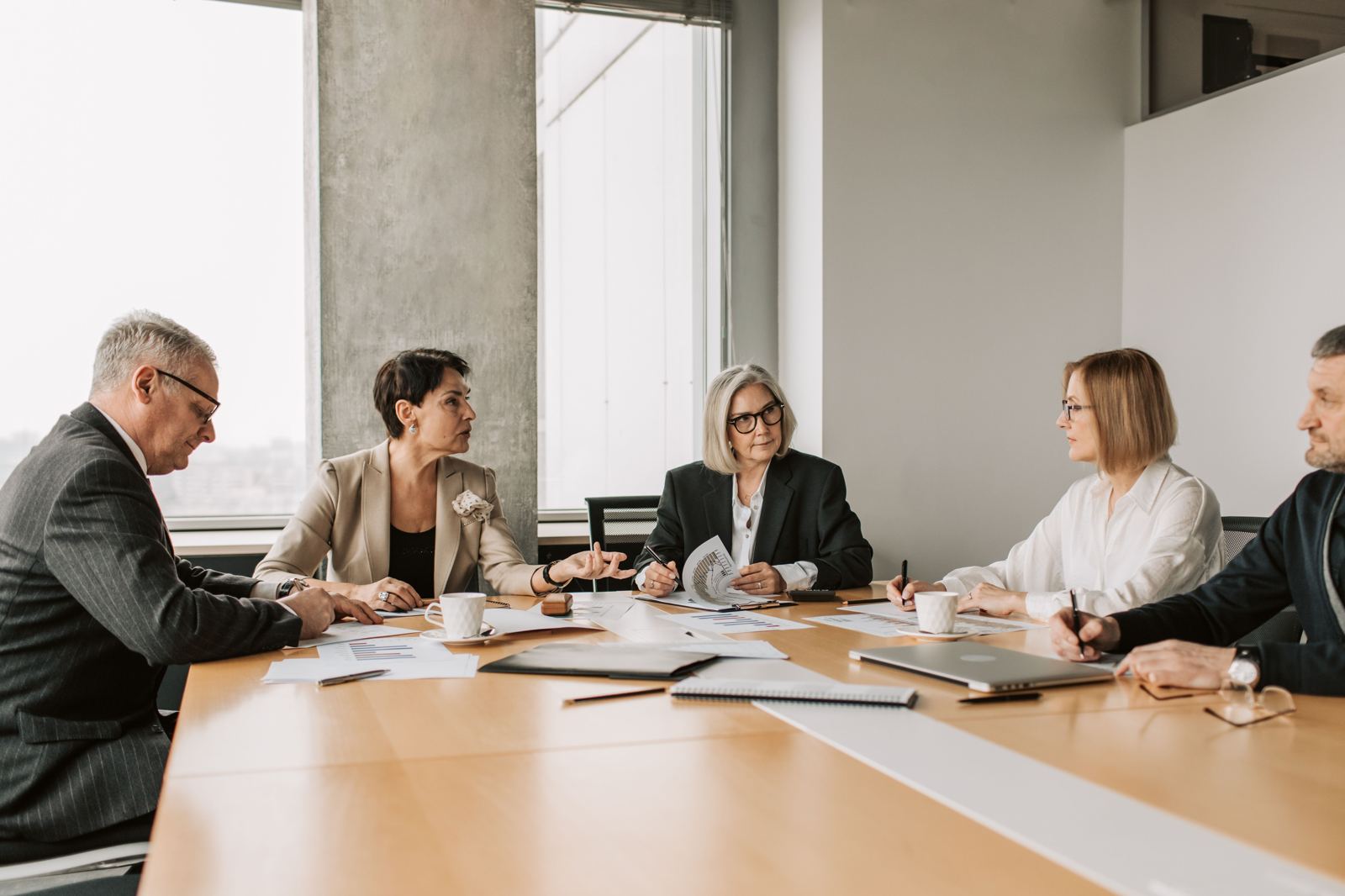 A finance and procurement team reviewing spend charts together around a table